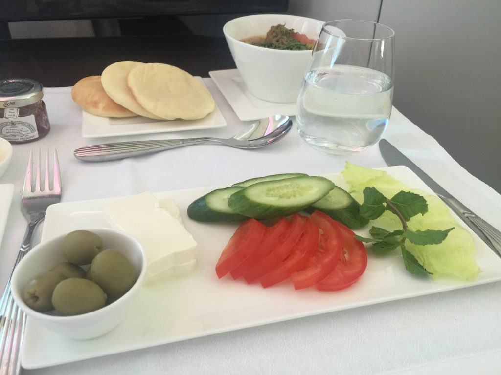 Klasa Biznes Qatar Airways B787 Dreamliner – tradycyjne arabskie śniadanie, czyli ser feta, ogórek, pomidor, zielone oliwki, bób z jogurtem i tahini oraz arabskie pieczywo 